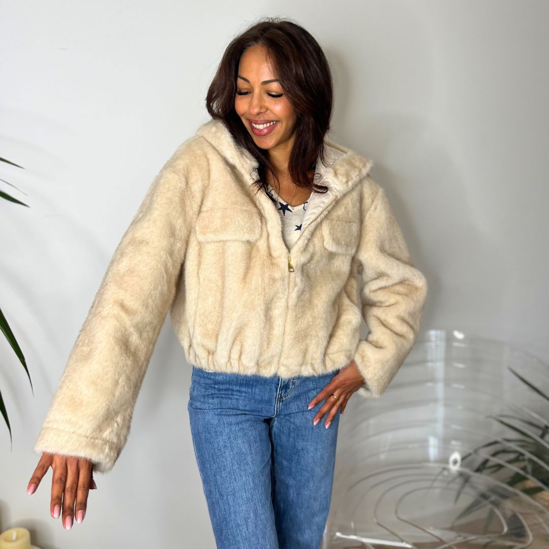Fausse fourrure à capuche ADELINE beige dotée d'une coupe courte et oversize resserrée en bas