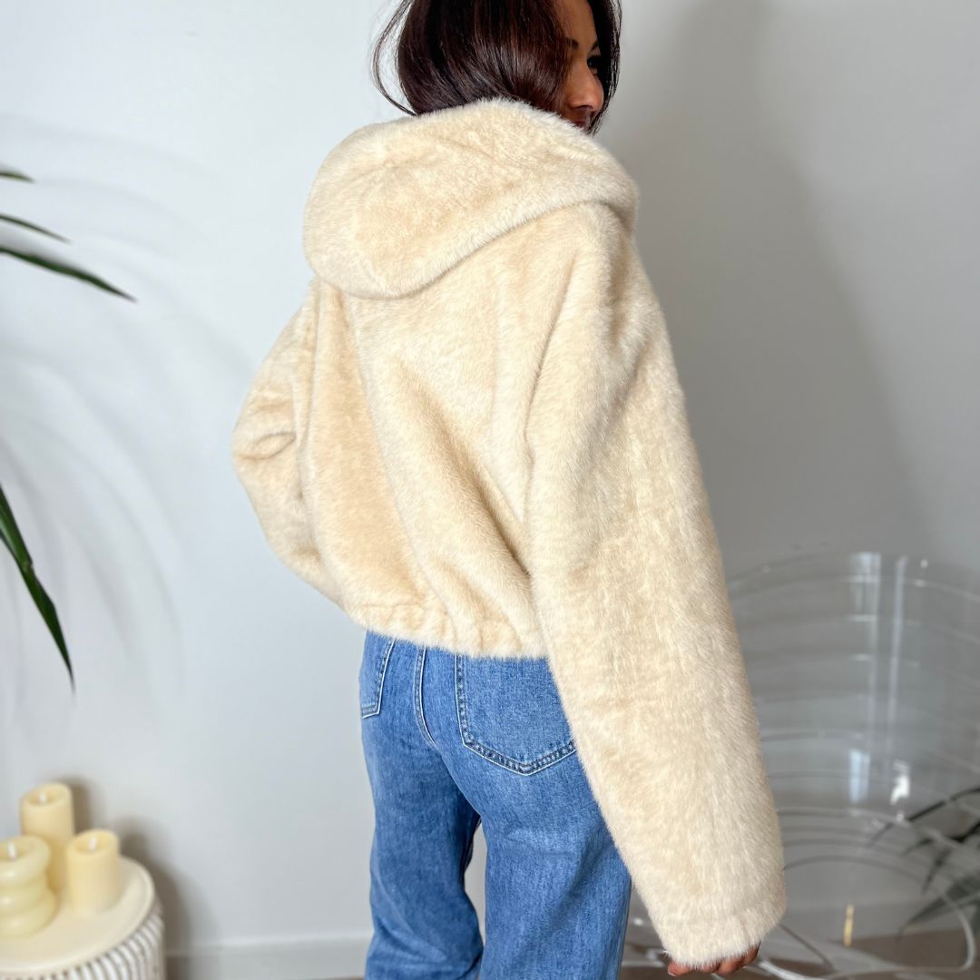 Fausse fourrure à capuche ADELINE beige dotée d'une coupe courte et oversize resserrée en bas
