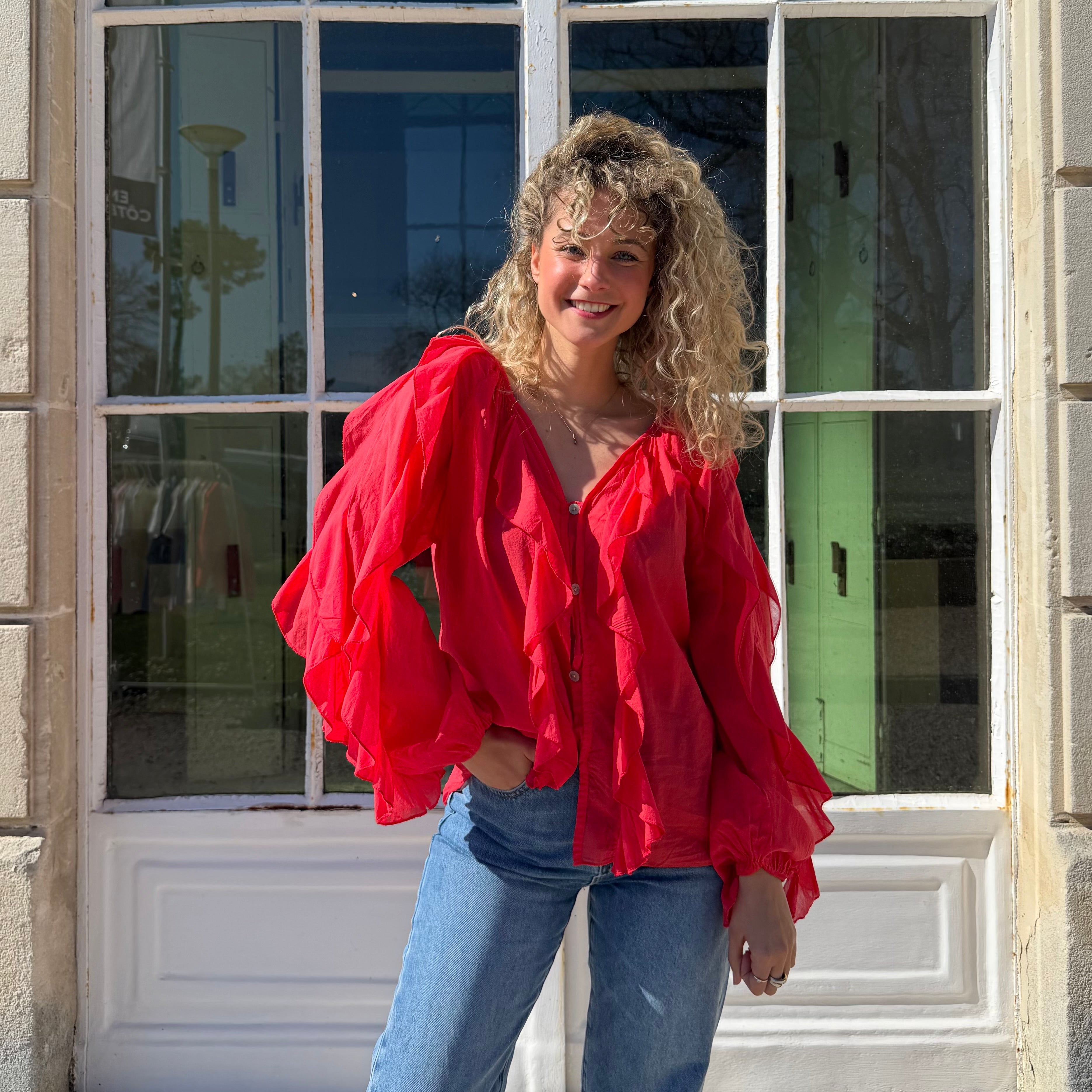 Blouse manches longues FLORA en coton rouge aux détails de volants.