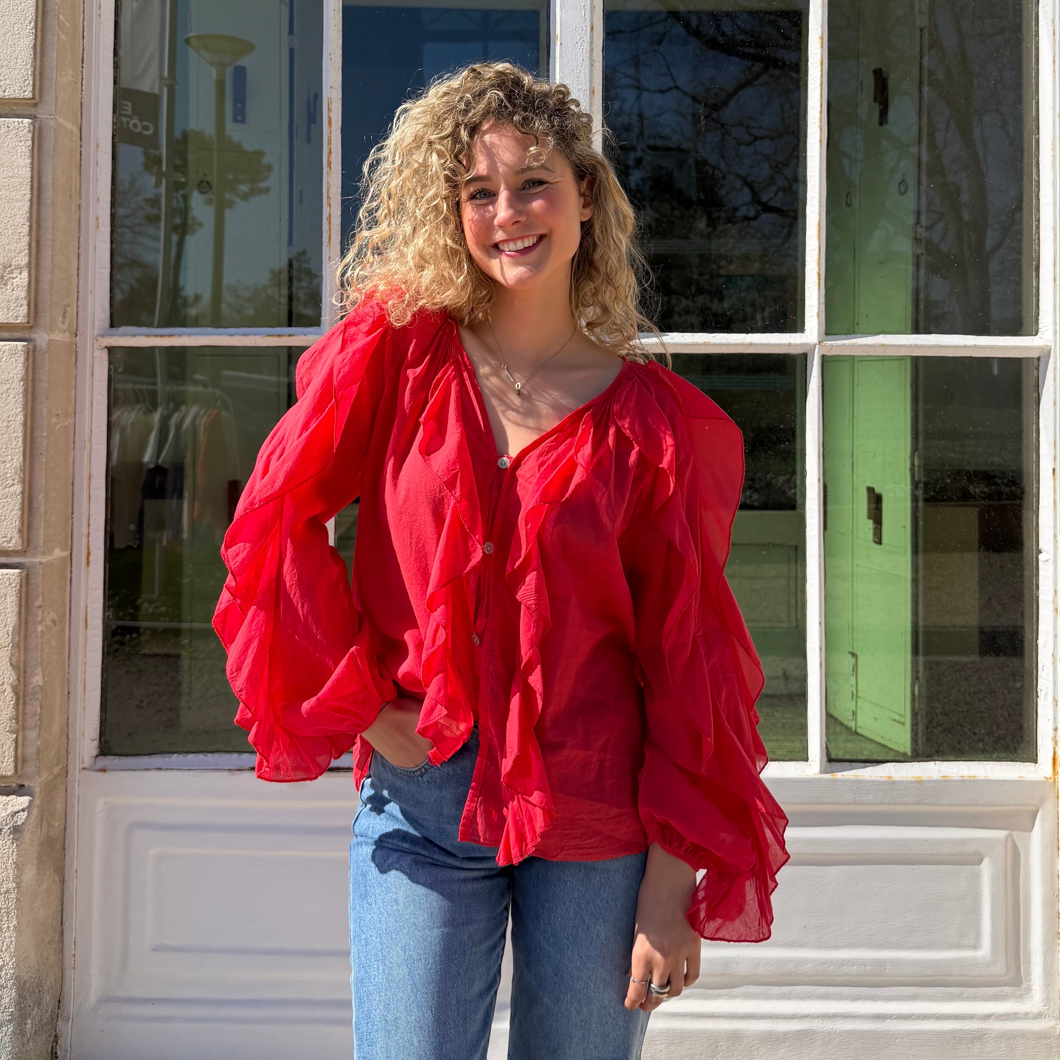 Blouse manches longues FLORA en coton rouge aux détails de volants.