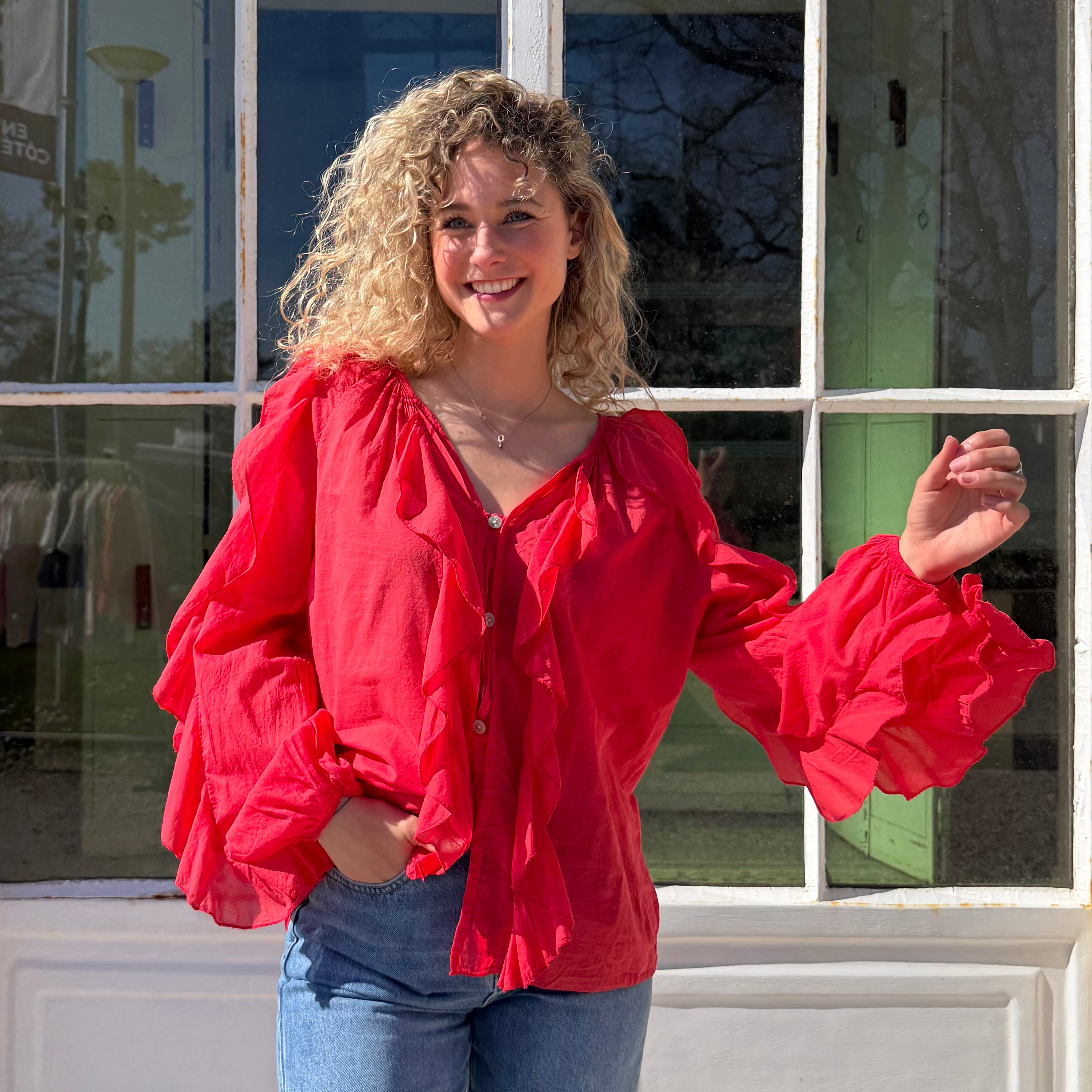 Blouse manches longues FLORA en coton rouge aux détails de volants.